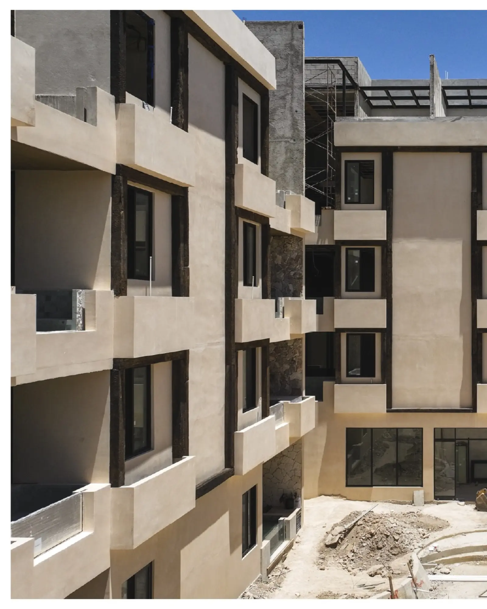 Fachada de un edificio residencial GCA4 en proceso de construcción, con andamios